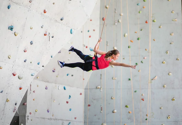 Žena na zdi visí horolezectví a létání na laně — Stock fotografie