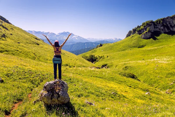 Bir kız ellerini kaldırdı. Mutluluk ve özgürlük dağlarında