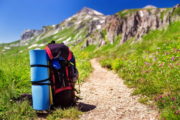 Tourist backpack with a rug near hiking trail in the mountains of the Caucasus, Adygea — Stock Photo, Image