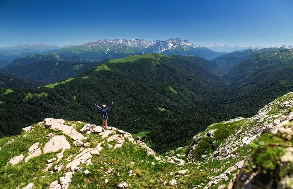 Női túrázó a hátizsák felemelte kezét ünnepli sikeres mászni a hegy tetején — Stock Fotó