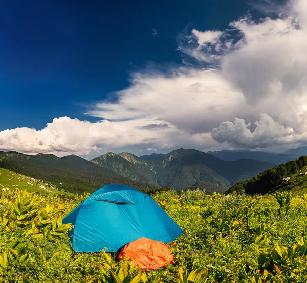 Палатка на траве под белыми облаками — стоковое фото