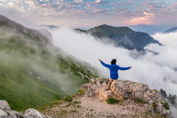 雲と霧の上の山のピークでハイキング若い女性バックパッカー — ストック写真