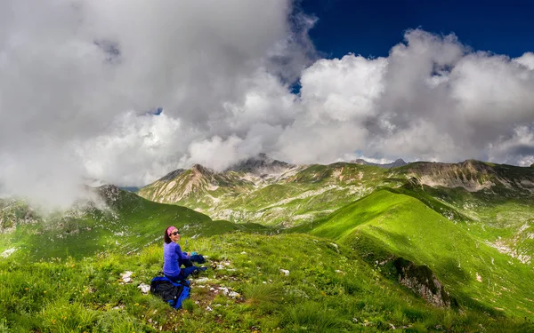 Mujer joven sentada en una roca y disfrutando de la vista del valle —  Fotos de Stock