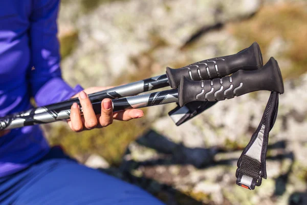 Hand holding a pair of hiking pole on nature background