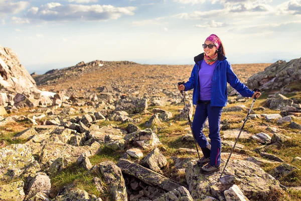 Mujer es trekking en las montañas entre el campo de piedras y rocas . — Foto de Stock