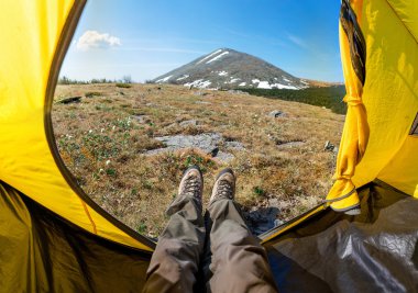 Kadın uzun yürüyüşe çıkan kimse llying dağ manzaralı bir çadırda