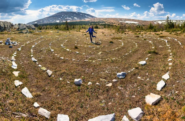 Stone spiraal op het veld op de berg met vrouw wandelaar — Stockfoto