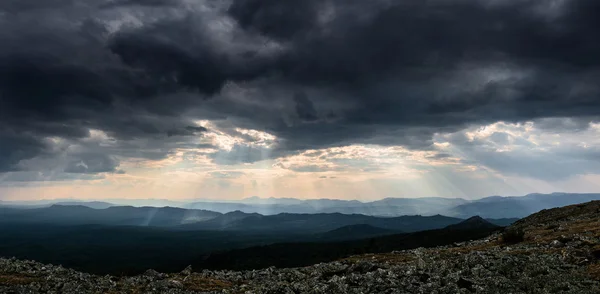 landscape with mountains and hills. sun rays dramatic at backgro