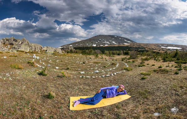 De vrouw ligt in de toeristische mat in de bergen — Stockfoto