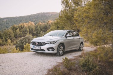 06 Eylül 2020, Antalya, Türkiye: Fiat Egea 'nın arabası dağlardaki bir ormanda toprak bir yola park edildi
