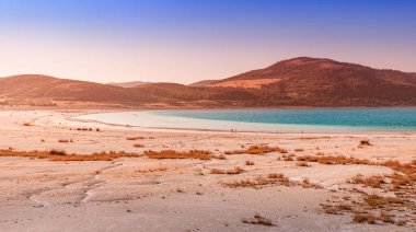 Türkiye 'deki ünlü Salda Gölü üzerinde çimen çalıları olan beyaz kumlu plajın panoramik manzarası. Doğanın harikaları ve Türk maldivleri konsepti