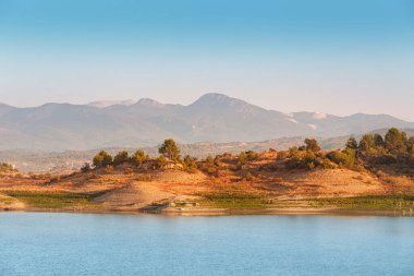 Sabahın köründe manzaralı bir manzara. Taurus dağlarının siluetleriyle donanımlı bir doğa. Türkiye 'nin Isparta bölgesinde Karacaoren Gölü.