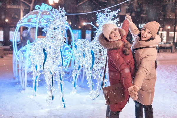 Girl Friends Having Fun Hugging Illuminated Fairy Tale Carriage Horses — Stock Photo, Image