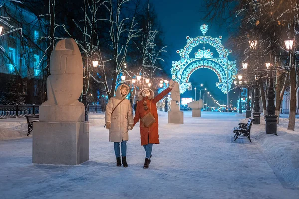 Счастливые Подруги Гуляют Вечернем Зимнем Парке Тротуару Фоне Новогодних Рождественских — стоковое фото