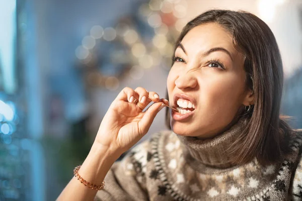 Funny woman smiles, winks and picks her teeth with a toothpick on a first date. Concept of bad manners and bad habits, as well as dental health