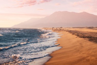Türkiye 'de Patara plajı yakınlarındaki Akdeniz sahilinin günbatımı manzarası. Arka planda büyüleyici dağlar var. Gizli doğal hazineler