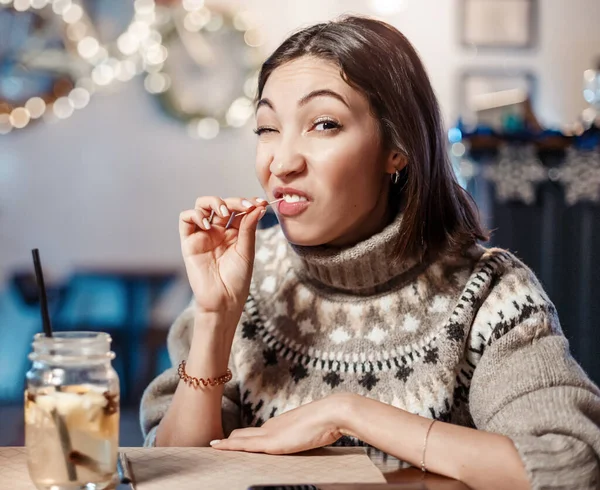 Funny woman smiles, winks and picks her teeth with a toothpick on a first date. Concept of bad manners and bad habits, as well as dental health