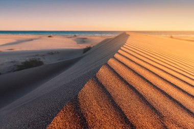 Patara plajı Türkiye 'de ünlü bir turizm merkezi ve doğal varış yeridir. Turuncu kum tepelerinin ve tepelerin görkemli manzarası ılık günbatımının ışınlarında parlıyor..
