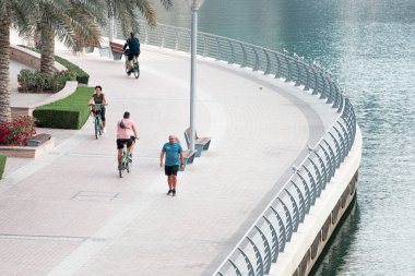 21 Şubat 2021, Dubai, BAE: İnsanlar Dubai Marina limanı boyunca koşuyor, yürüyor ve bisiklet sürüyor