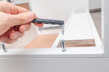 Büyülü anahtarı olan bir erkek el ve evde mobilya montajı üzerinde çalışmak ve bağlayıcılar konsepti olarak onaylayıcı ekranlar.