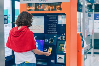 23 Şubat 2021, Dubai, BAE: Bir kadın yolcu otomatik bir kasiyer kullanarak Dubai 'deki bir tramvay veya metro için nakliye kartını dolduruyor.