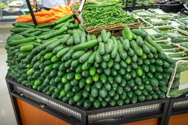 Salatalık ve diğer yeşil sebzeler çiftçi pazarında ya da süpermarkette bir marketin tezgahında.