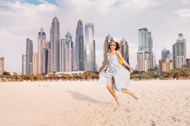 Dubai 'deki devasa gökdelenlerin arka planında mayo giymiş komik bir kadın.