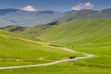 Yalnız bir kamyon değerli bir kargoyla tehlikeli bir dağ yolunda ilerliyor. Uzaktan üst görünüm.