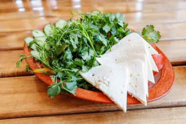 Ermeni mezeleri, taze organik keçi peyniri dilimlenmiş ve bir sürü maydanoz. Sağlıklı ve lezzetli.