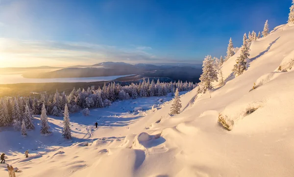 Winterlandschaft mit Wanderern und Skifahrern bei Sonnenaufgang — Stockfoto