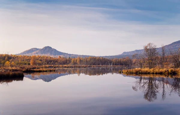 Reflektion över berg och träd i blått vatten — Stockfoto