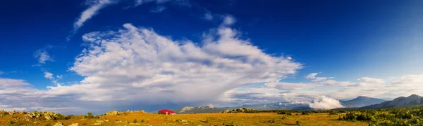 Táj, a kék ég és a kunyhóba a hegyekben — Stock Fotó