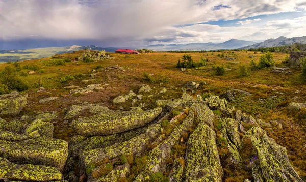 Landskap med stormig himmel och hus i bergen — Stockfoto