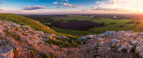 Зеленая долина с полем на закате — стоковое фото