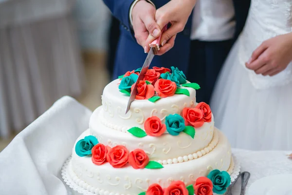 Recém-casados cortando o bolo de casamento — Fotografia de Stock