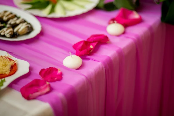 Mesa de boda decorada con pétalos de rosa — Foto de Stock