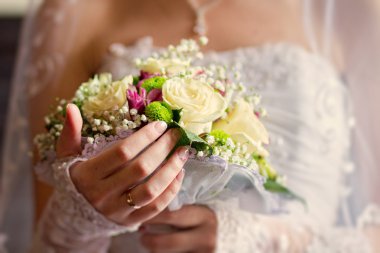 Gelin düğün buketi tutuyor.