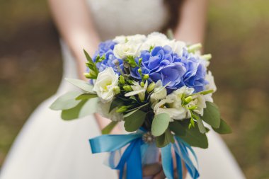 Gelin düğün buketi tutuyor.