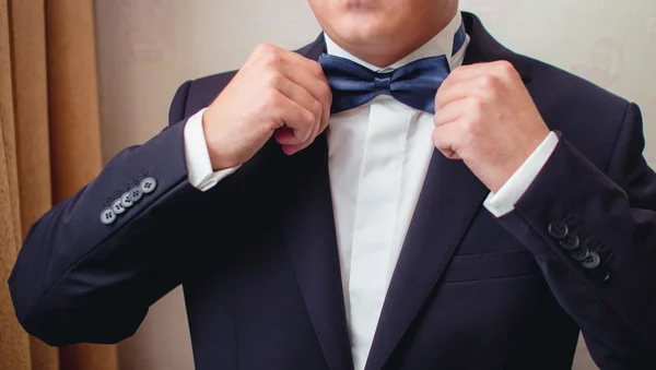 Man in the suit straightens bow tie — Stock Photo, Image