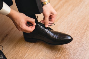 Ayakkabı bağcığı bağlayan adam.