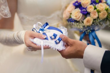 Gelin ve damat bir yastık yüzük ile tutarak