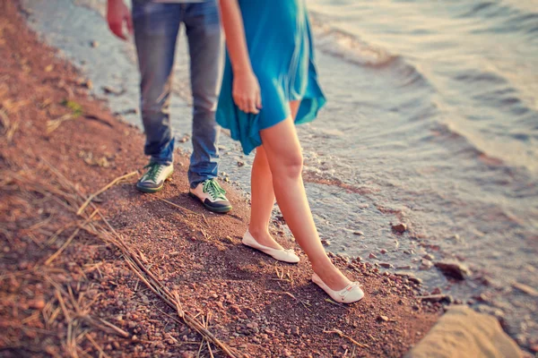 Любящая пара гуляет по пустынному пляжу на закате — стоковое фото