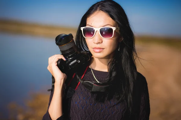 Молодая женщина с фотоаппаратом на улице портрет — стоковое фото