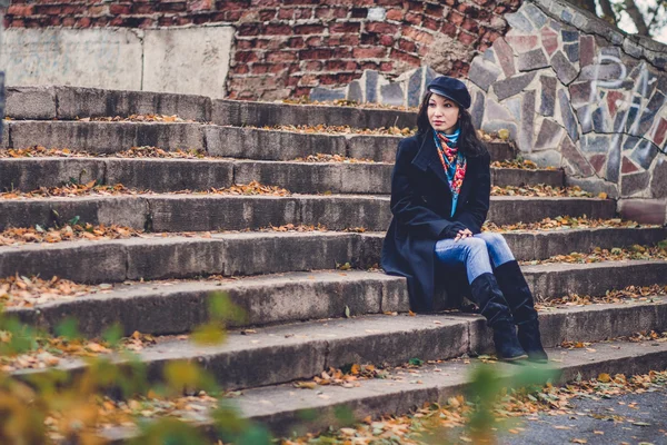 Γυναίκα που κάθεται στα παλιά τα σκαλοπάτια στο πάρκο φθινόπωρο — Φωτογραφία Αρχείου