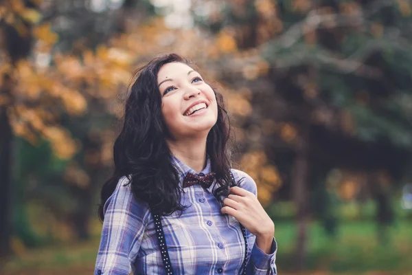 Смеющаяся модная девушка в осеннем парке — стоковое фото