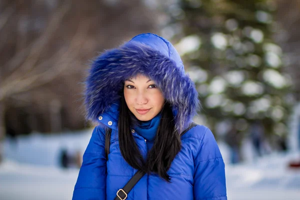 Brunett i blå huva i vinter skog — Stockfoto