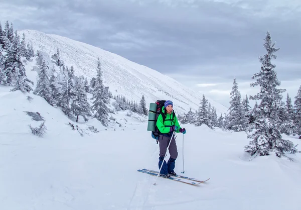 Esquiador en el campo nevado cerca de la gran montaña — Foto de Stock