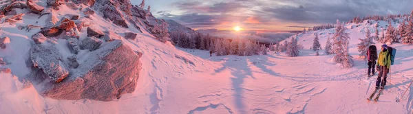 Skiërs zonsopgang kijken in winter bergen — Stockfoto