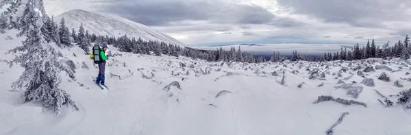 Skifahrer auf einem verschneiten Feld in der Nähe der großen Felsen — Stockfoto