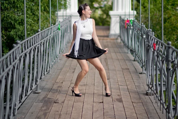 Dancing girl in short skirt in city park — Stock Photo, Image